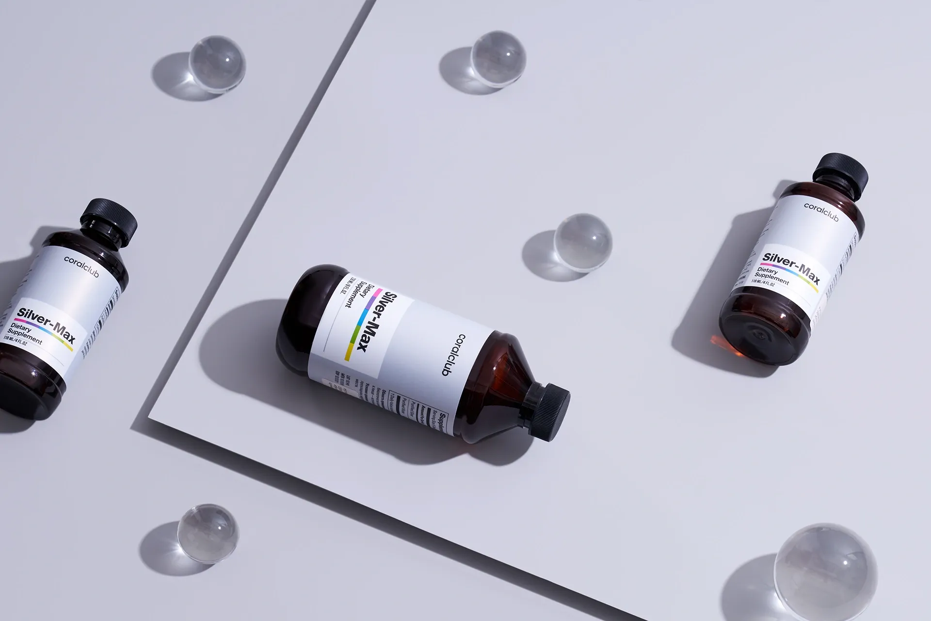 Silver-Max bottles in an aesthetic lifestyle environment with decorative spheres, emphasizing product purity